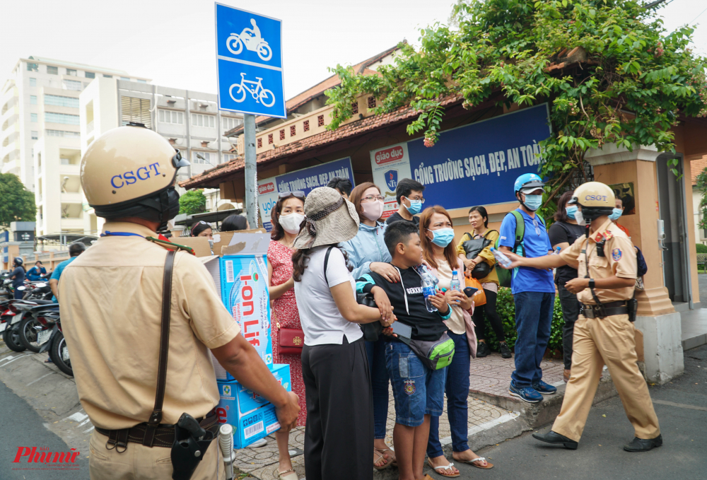 Lực lượng CSGT phát nước uống cho phụ huynh đợi con trước Trường THPT chuyên Lê Hồng Phong