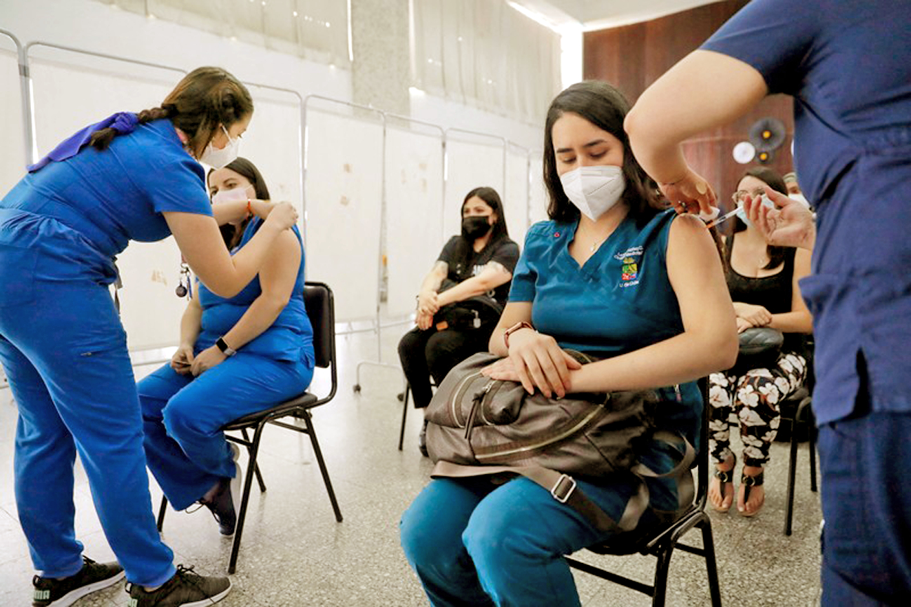 Các nhân viên y tế ở Chile đang tiêm liều vắc-xin COVID-19 thứ 4 - ẢNH: AFP