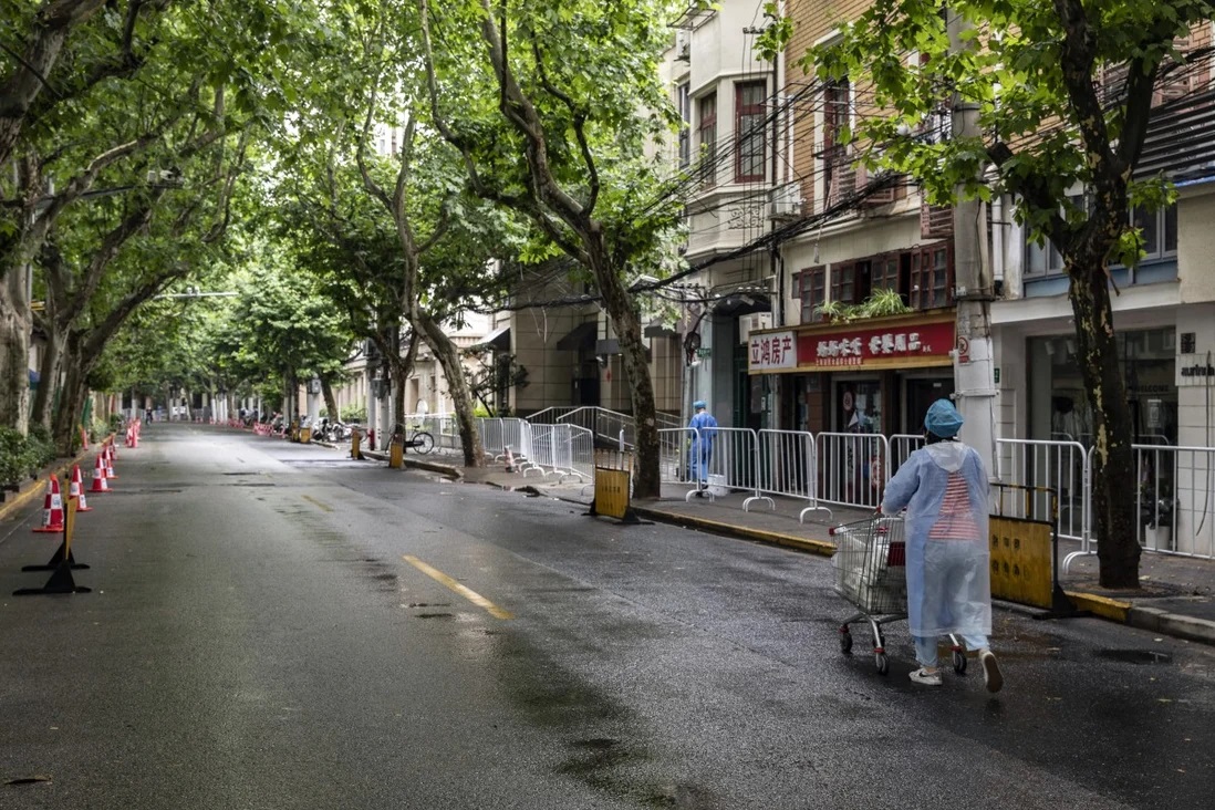 Nhân viên y tế trong trang bị bảo hộ cá nhân đẩy xe chở đồ ăn trưa cho người dân tại một khu phố bị phong tỏa ở Thượng Hải.