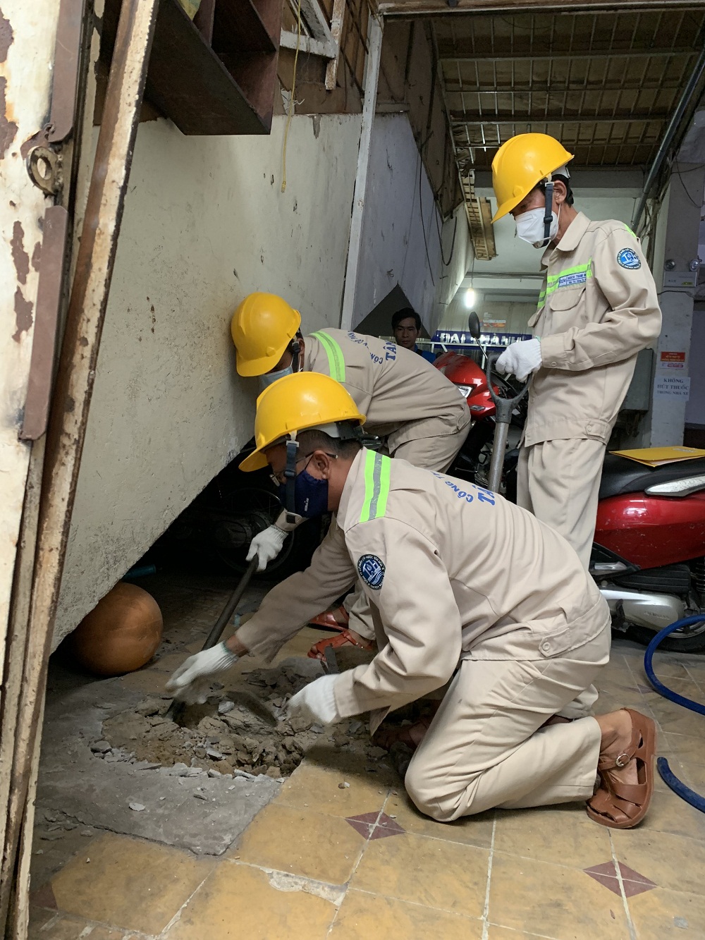 Nhân viên Cấp nước Tân Hòa trám lấp giếng khoan cho người dân tại quận Tân Phú - Ảnh: Sawaco