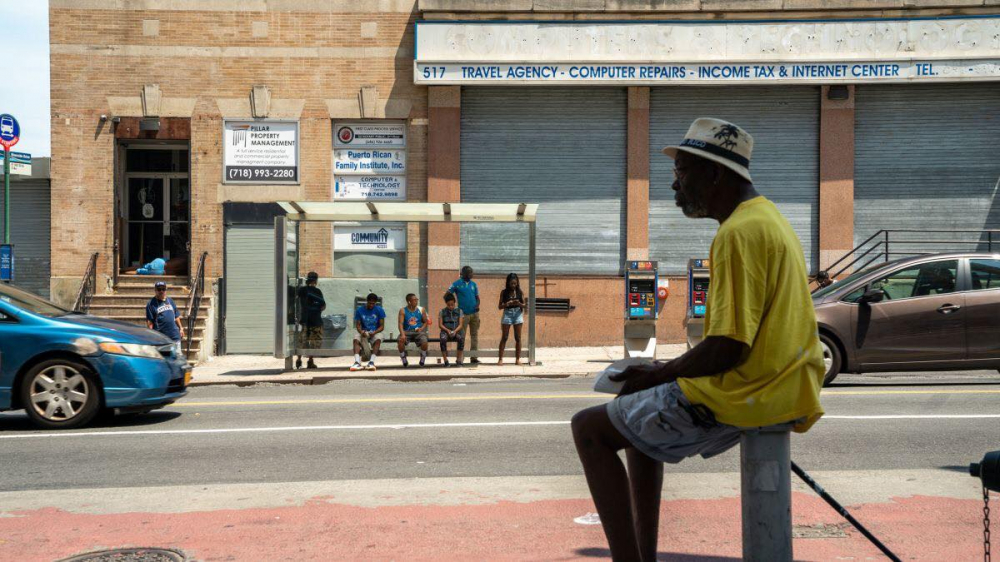 Một người đàn ông  gốc Phi tránh nắng tại một trạm xe buýt ở quận Bronx, New York City, Mỹ