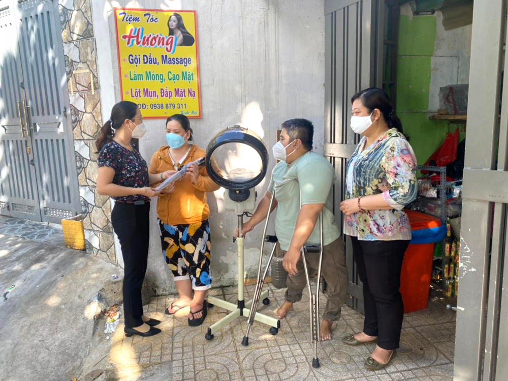 Hội LHPN Q.Bình Tân tặng máy hấp dầu (dụng cụ làm tóc) và động viên vợ chồng chị Hương (thứ hai, từ trái qua) tiếp tục nỗ lực vươn lên trong cuộc sống