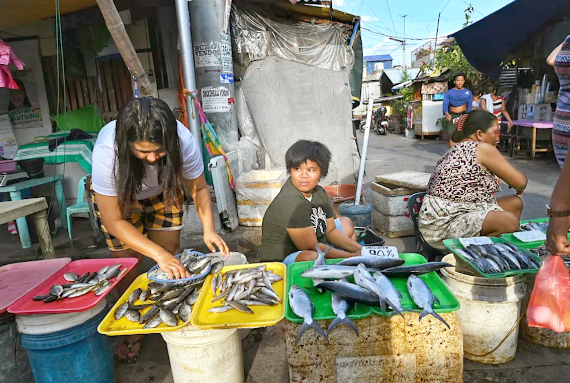 Tình trạng giá lương thực, thực phẩm tăng cao khiến đời sống của người dân châu Á gặp nhiều khó khăn (trong ảnh: Người dân bán cá ở chợ đường phố tại quận Tondo, thủ đô Manila, Philippines) - ẢNH: AFP