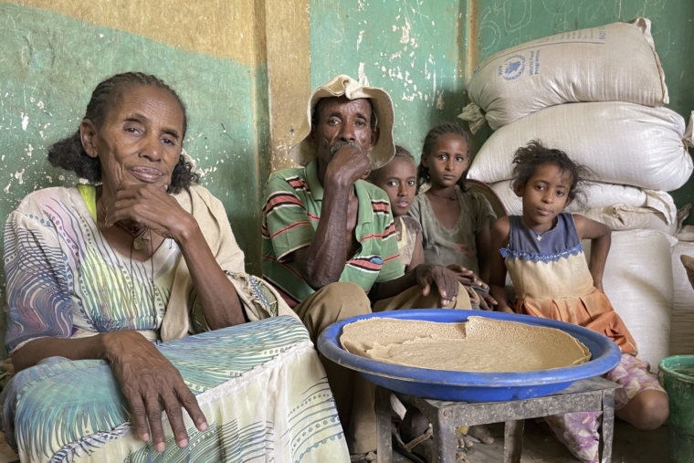 Tesfay, trung tâm, ngồi với vợ và cháu của mình, những người đã phải rời bỏ nhà cửa trong 18 tháng, khi họ nhận được hỗ trợ lương thực lần đầu tiên sau tám tháng từ Chương trình Lương thực Thế giới ở phía tây Tigray, Ethiopia