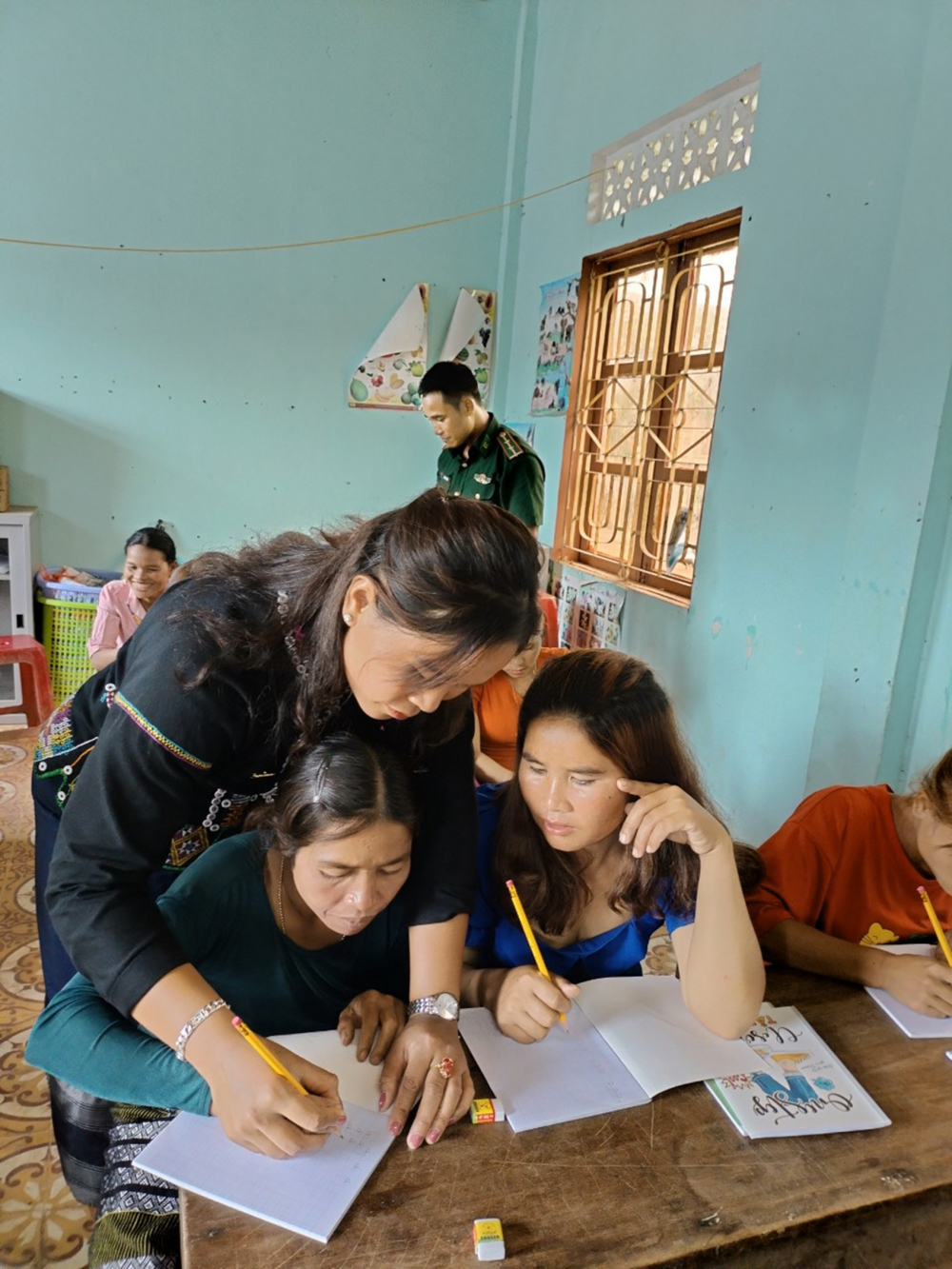 Chị Hồ Thị Tê, Chủ tịch Hội LHPN xã Thanh,  cầm tay giúp các chị em viết từng nét chữ