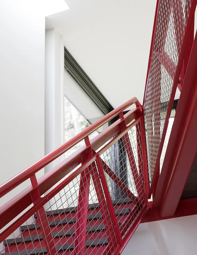 Dây thép và lưới kim loại được sơn tĩnh điện màu đỏ sáng bóng tạo nên một trung tâm lấy cảm hứng từ công nghiệp lấy cảm hứng từ cảnh trong công trình tân trang ngôi nhà nhẹ nhàng và thoáng mát này từ OreStudios có trụ sở tại Seattle.