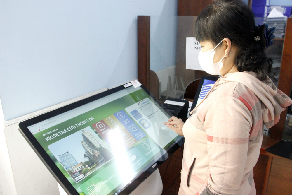  Người dân tra cứu thông tin trên bảng điện tử ở trụ sở UBND xã Vĩnh Lộc A