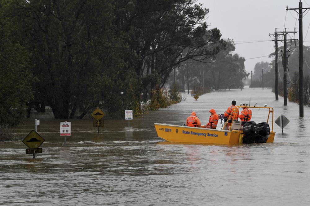 Thành viên Dịch vụ Khẩn cấp Bang New South Wales (SES) sử dụng thuyền cứu hộ để tiếp cận khu dân cư khi các con đường bị nhấn chìm dưới nước lũ từ sông Hawkesbury ở Windsor, phía tây bắc Sydney
