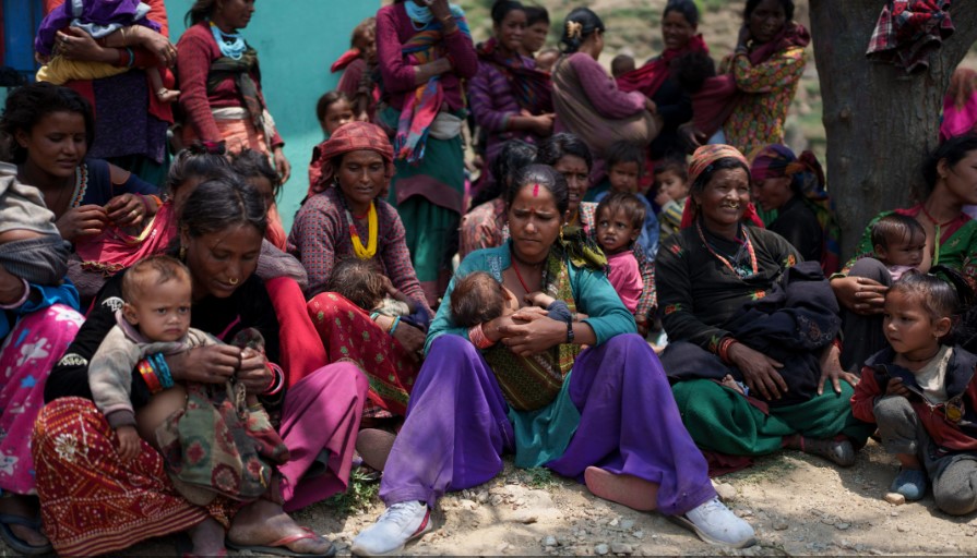 Những phụ nữ có con bị suy dinh dưỡng chờ đợi bên ngoài một tế bào y tế ở Muktikot. [Niranjan Shrestha / Al Jazeera]