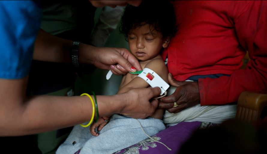 nhân viên y tế đo chu vi cánh tay giữa một nhóm trẻ bị suy dinh dưỡng. [Niranjan Shrestha / Al Jazeera]