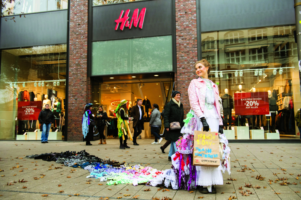 Một nhà hoạt động của tổ chức Green Peace trình diễn chiếc váy “Nữ hoàng thùng rác” dài 7m làm từ quần áo đã qua sử dụng với thông điệp “Trào lưu hôm nay, rác thải ngày mai”