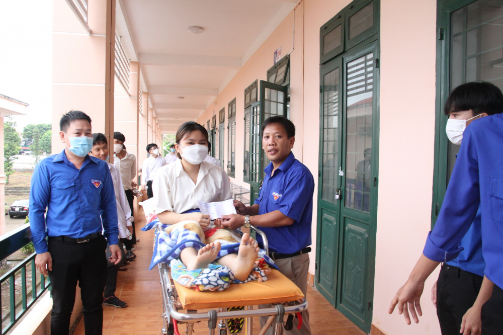 nữ sinh Hà Thanh Trâm, lớp 12A6, Trường THPT Thanh Hòa, huyện Bù Đốp, tỉnh Bình Phước đến điểm thi bằng xe cứu thương, vào phòng thi trên cáng
