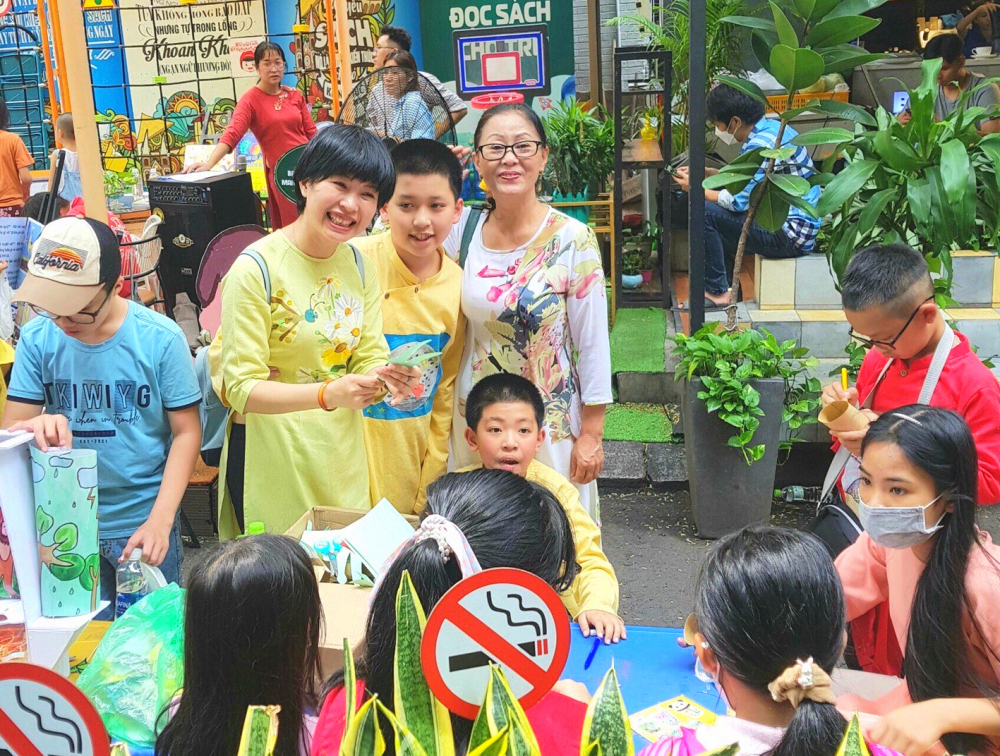 Chị Uyên Thi cùng hai con trai hướng dẫn các bạn nhỏ làm con rối tại Đường sách Nguyễn Văn Bình, TP.HCM