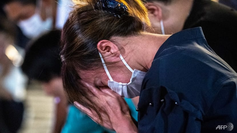 Một người phụ nữ bật khóc tại hiện trường nơi ông Abe ngã xuống, phía trước ga xe lửa ở Nara