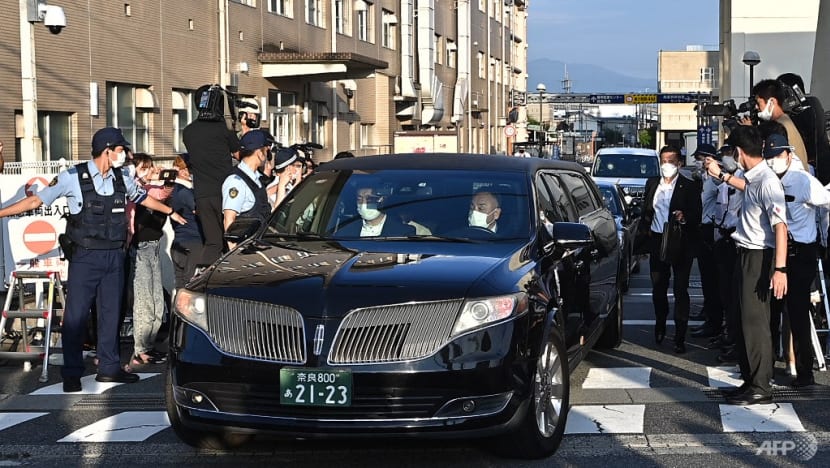 Chiếc xe được cho là chở thi hài của cố thủ tướng Nhật Bản Shinzo Abe đi ngang qua cảnh sát và giới truyền thông bên ngoài Bệnh viện Đại học Y Nara ở Kashihara, tỉnh Nara