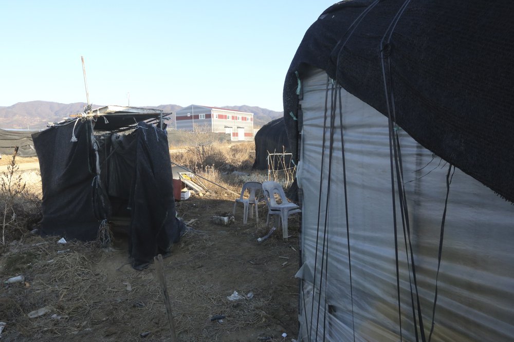 Nhà vệ sinh tạm bợ được dựng lên bên ngoài khu nhà ở của những lao động nhập cư - Ảnh: Ahn Young-joon/AP