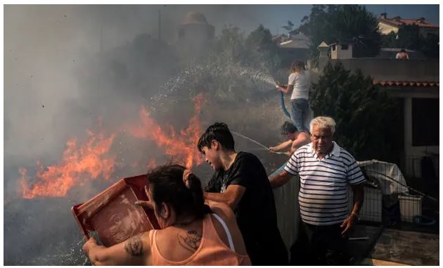 Người dân Mọi người tạt nước và vòi rồng vào ngọn lửa gần nhà của họ ở Canecas, ngoại ô Lisbon. 