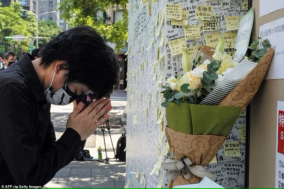 Một người đàn ông cầu nguyện trước bức tường tưởng nhớ cố thủ tướng Shinzo Abe