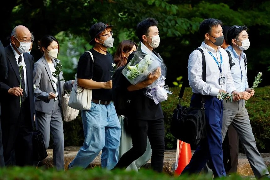 Nhiều nhân viên tại Tokyo đến đặt hoa cho cựu thủ tướng Nhật Bản Shinzo Abe tại đền Zojoji vào chiều 11/7