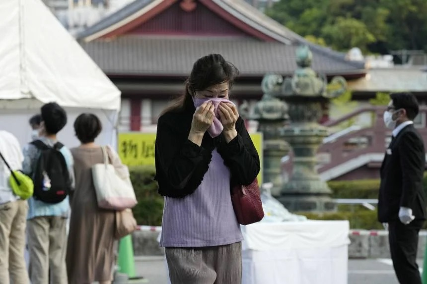 Một phụ nữ khóc sau khi đặt hoa tưởng nhớ cựu thủ tướng Nhật Bản Shinzo Abe