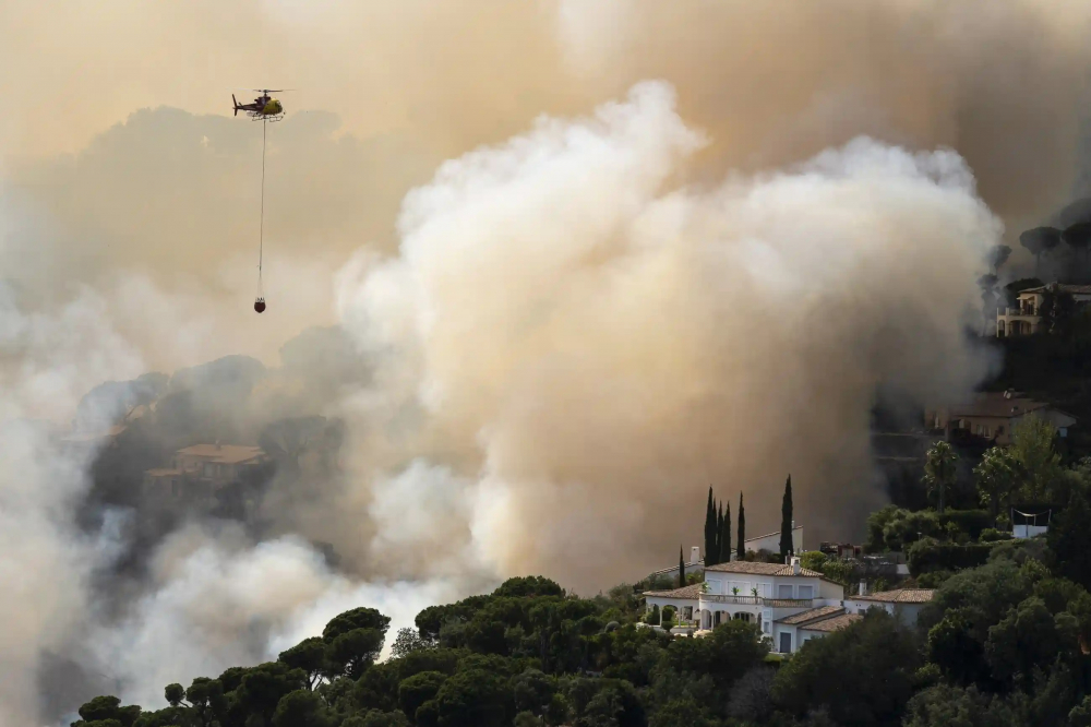 Từ ngày 1/1 đến ngày 3/7, hơn 70.300 ha rừng đã bốc cháy ở Tây Ban Nha - gần gấp đôi mức trung bình của 10 năm qua. Trong ảnh, một chiếc trực thăng đổ nước vào đám cháy rừng ở Santa Cristina d’Aro, thành phố Girona vào ngày 1/7