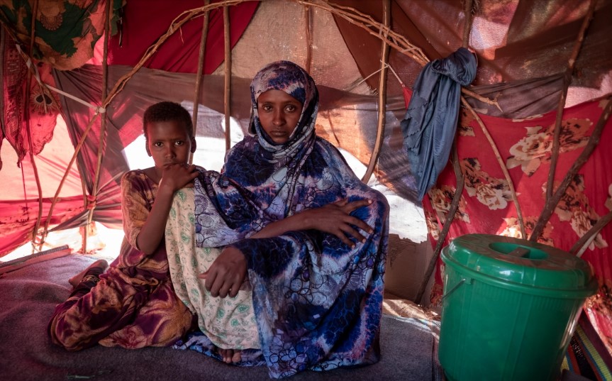 Fatuma Mohamed, 30 tuổi và cô con gái 8 tuổi Naney Adam Abdi đã ở trong trại tạm thời IDP ở Dollow, Somalia trong ba tháng rưỡi. Họ đến từ Ethiopia. Cô ấy nói chúng tôi đã ở trong một trại ở Ethiopia nhưng chúng tôi không có đủ nước hoặc thức ăn. Trước đó hạn hán rất tồi tệ nhưng lần này chúng tôi không có động vật và không có trang trại. [Rich / UNICEF]