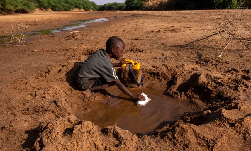 Một cậu bé thu thập lượng nước ít ỏi có thể từ một con sông khô cạn ở Dollow Somalia. [Rich / UNICEF]