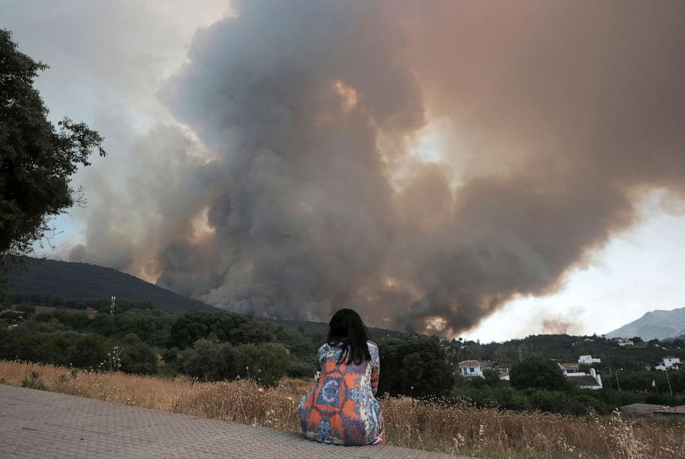 Một người phụ nữ đứng nhìn khi đám cháy rừng bùng phát gần khu dân cư ở Alhaurin de la Torre, Malaga, Tây Ban Nha, ngày 16/7/2022.