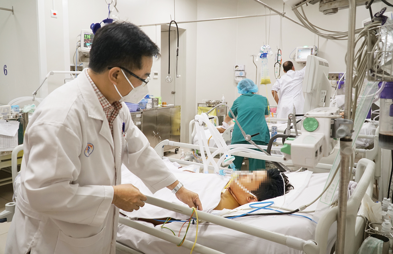 Bác sĩ Lê Quốc Hùng đang kiểm tra sức khỏe cho anh T. Trước đó, anh trai của T. đã tử vong vì sốt xuất huyết - ẢNH: TAM NGUYÊN