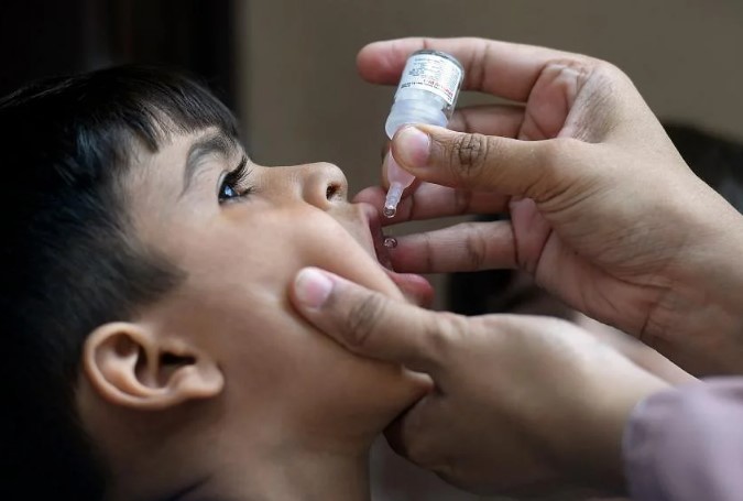 Một em nhỏ đang được uống vắc xin ngừa bại liệt