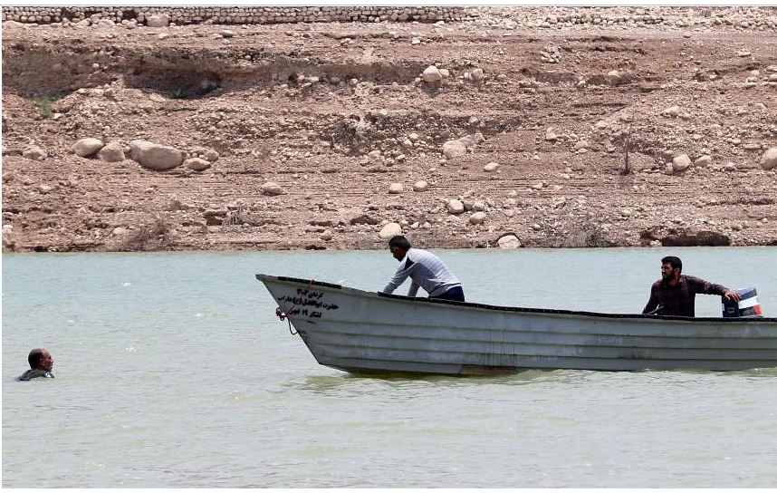 Một chiếc thuyền tiếp cận một người đàn ông trên sông ở Iran, sau khi lượng mưa lớn gây ra lũ lụt.