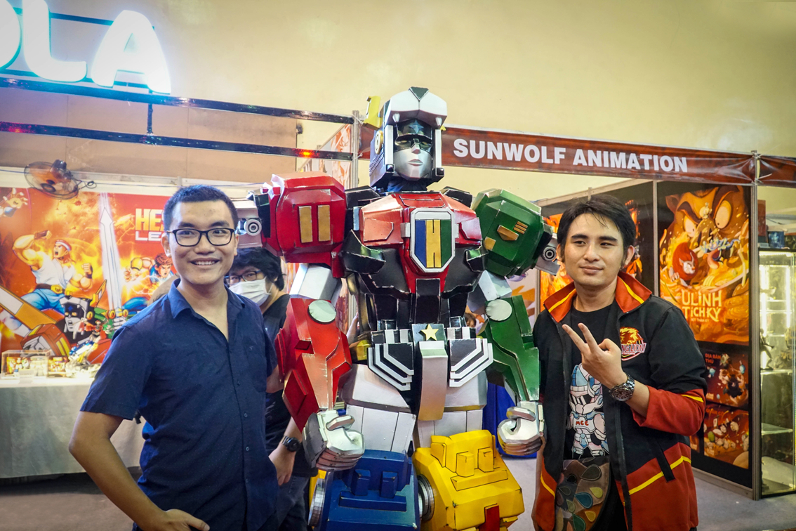 Anh Nguyễn Khánh Dương (bên trái) - CEO của Comicola và anh Tô Quốc Nghi, đại diện đơn vị tổ chức bên mô hình dũng sĩ Hesman - ẢNH: TAM NGUYÊN