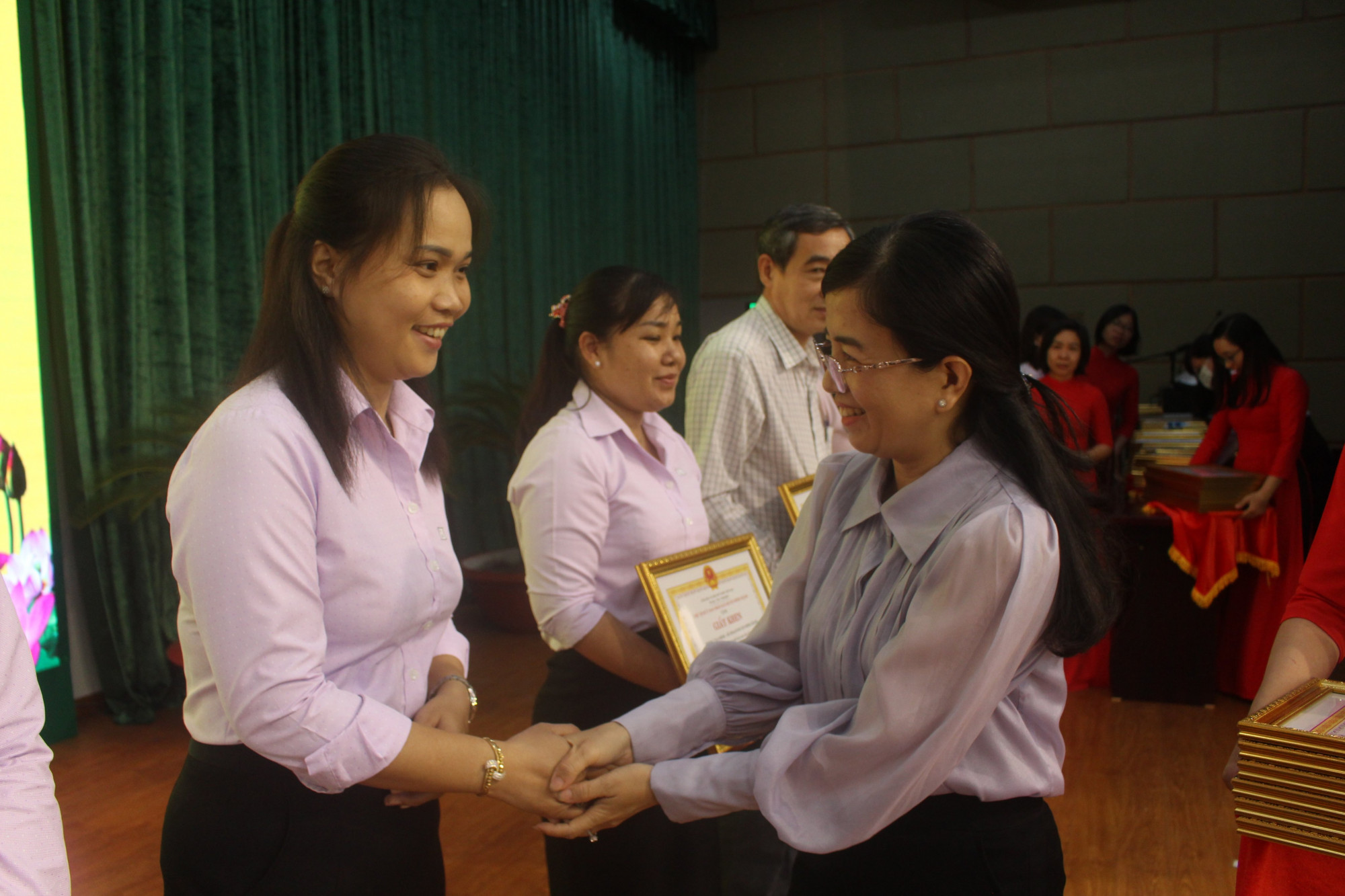 Bà Nguyễn Thị Hồng Nhung - Giám đốc NHCSXH huyện Bình Chánh tặng bằng khen cho các cá nhân phối hợp thực hiện tốt chính sách tín dụng ưu đãi đối với hộ nghèo và các đối tượng chính sách khác 