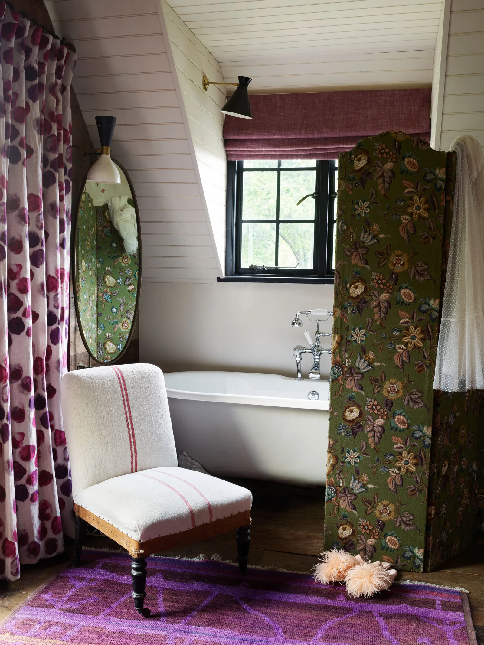 Một chiếc bồn tắm từ The Architectural Forum nằm sau bức bình phong phủ vải thời Victoria ở một góc phòng ngủ của Miller.