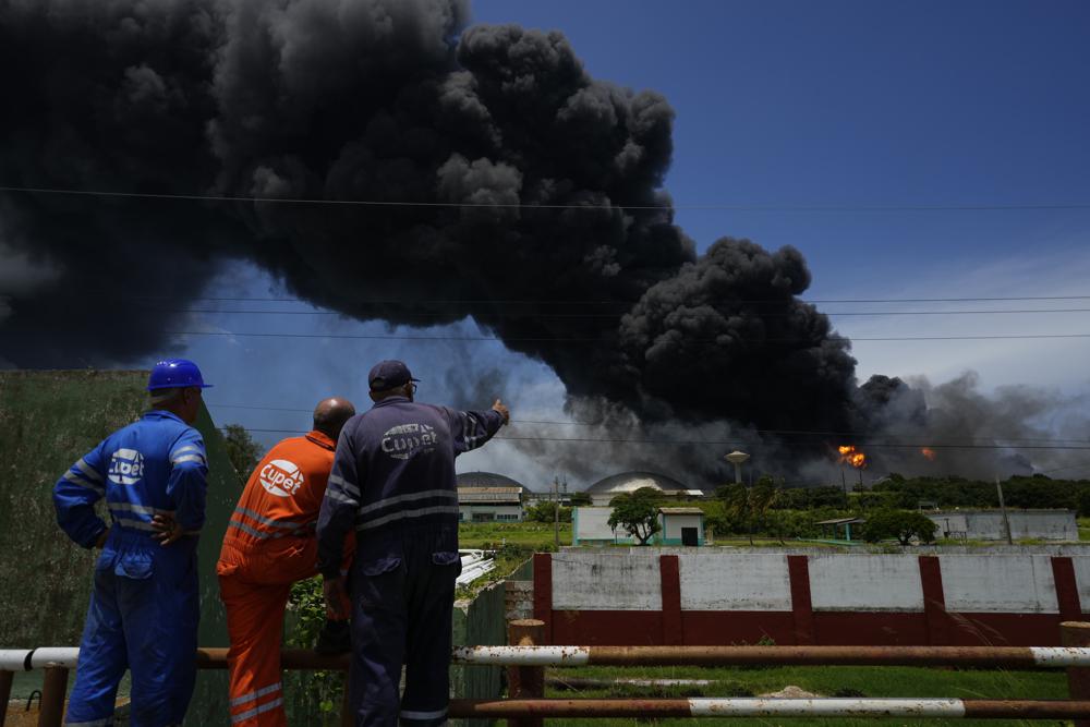 Công nhân của Liên minh Dầu mỏ Cuba theo dõi một đám khói khổng lồ bốc lên từ Khu siêu bồn chứa Matanzas