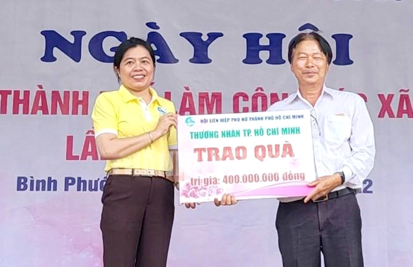 Bà Nguyễn Trần Phượng Trân - Chủ tịch Hội LHPN TP.HCM - trao bảng tượng trưng tặng quà với tổng trị giá 400 triệu đồng cho Trung tâm Bảo trợ xã hội Bình Đức