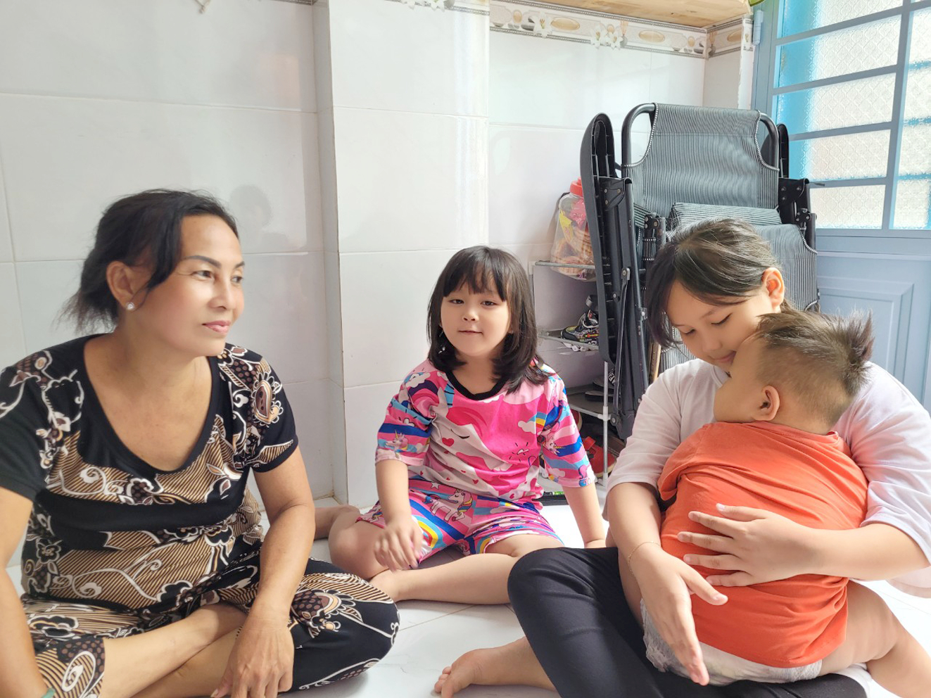 Mỗi khi nhìn ba đứa cháu nhỏ mồ côi mẹ, bà Nguyễn Kim Loan (bìa trái) tự dặn mình phải mạnh mẽ để lo cho cháu