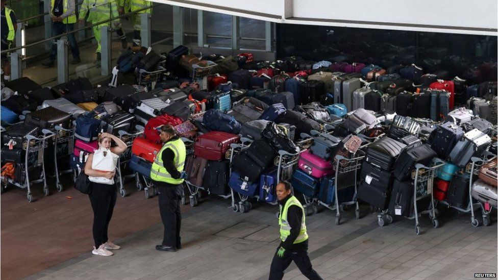 Thiếu nhân lực làm công việc bốc xếp hành lý khiến các sân bay luôn trong tình trạng quá tải - Ảnh: Reuters