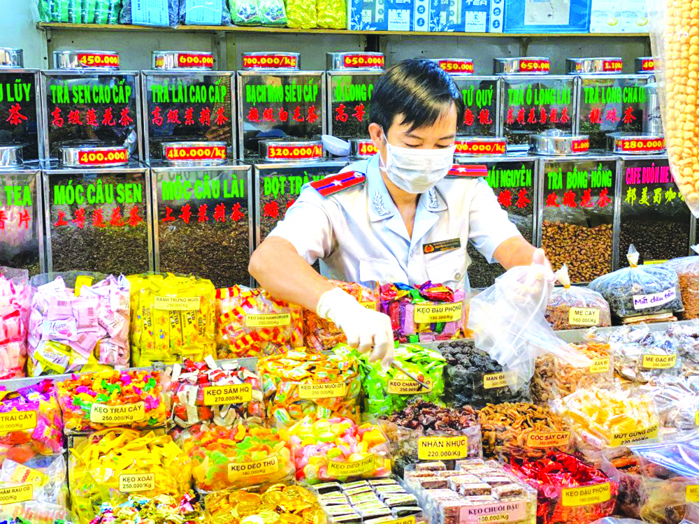 Đoàn kiểm tra của Ban Quản lý an toàn thực phẩm TP.HCM lấy mẫu bánh kẹo tại chợ An Đông trong năm 2021 ẢNH: QUỐC THÁI