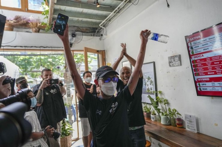 Khách hàng đầu tiên trong ngày, Rittipomng Bachkul, ăn mừng sau khi mua cần sa hợp pháp tại quán cà phê Highland ở Bangkok, Thái Lan vào ngày 9/6