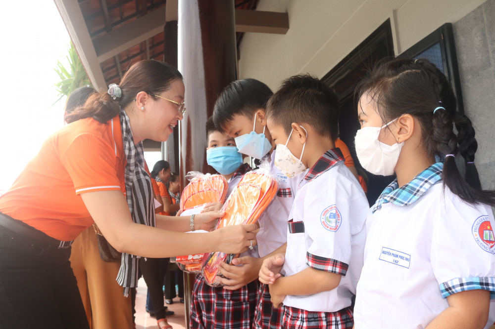Bà Huỳnh Đặng Hà Tuyên - Chủ tịch Hội LHPN quận Bình Tân - trao quà cho các em học sinh. 
