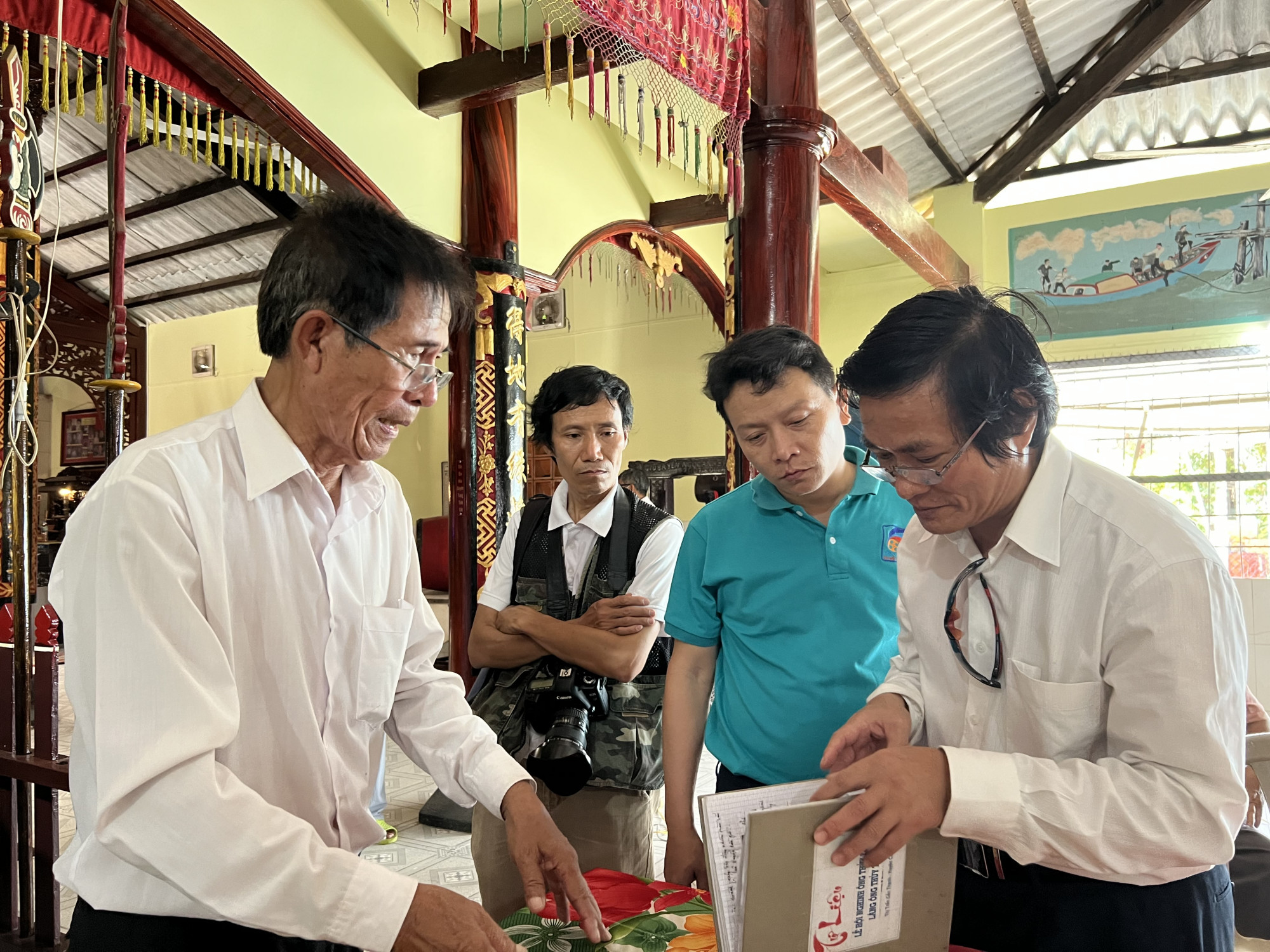 Nghệ nhân dân gian Phan Văn Chấn (trái) giới thiệu về kiến trúc lăng và lịch sử hình thành lễ hội Nghinh Ông