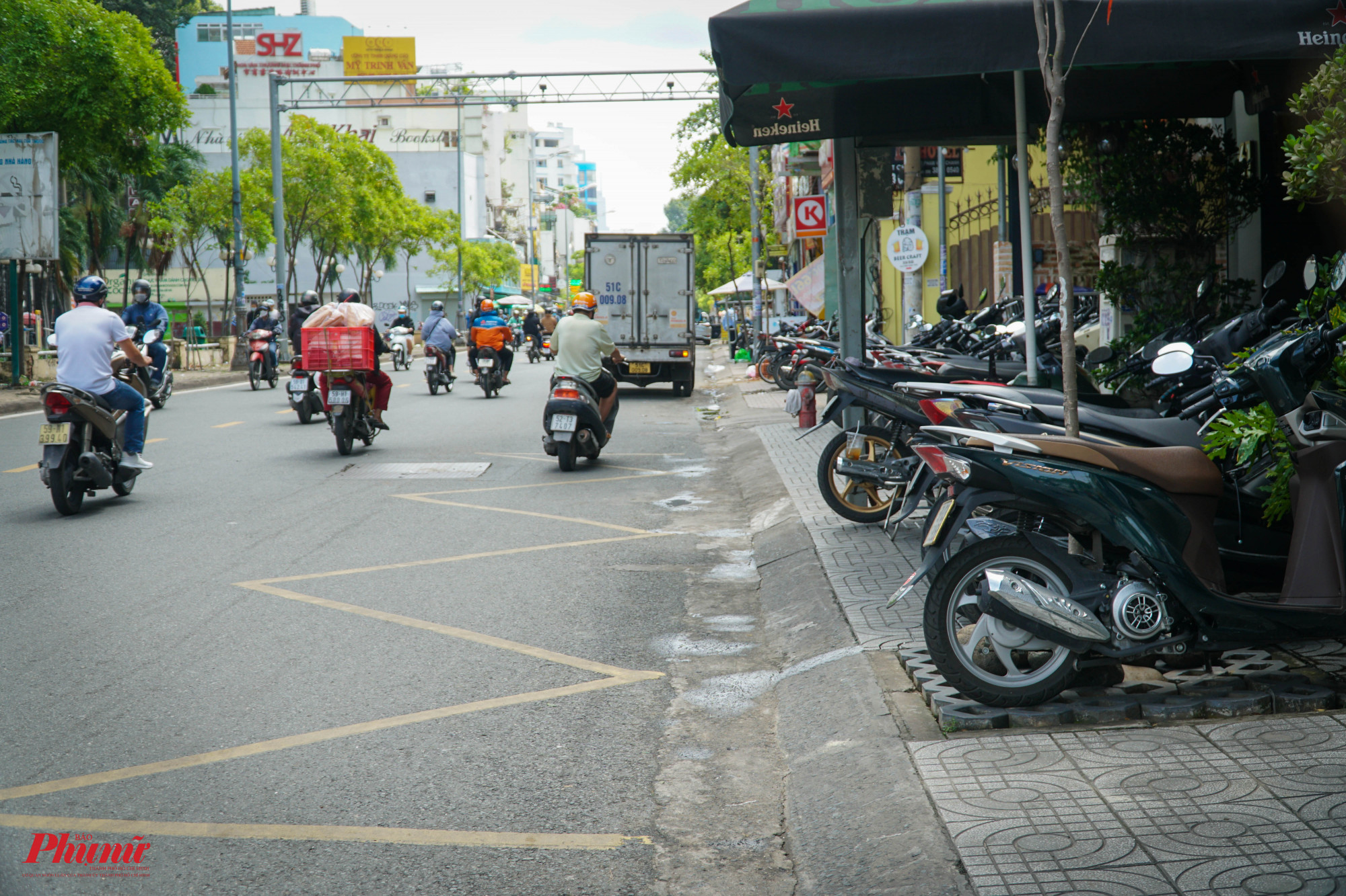 trên đường Phạm Viết Chánh (quận 1), người dân buộc phải đón xe buýt dưới lòng đường, khi vỉa hè trở thành nơi đậu xe của các cửa hàng ngay đó