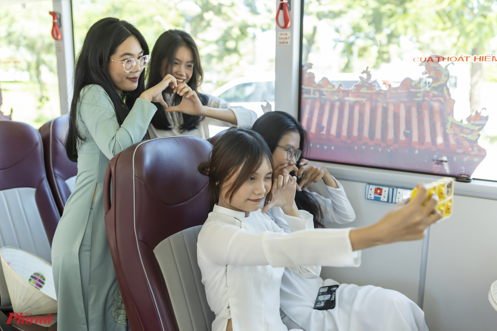 Bạn trẻ check in trên xe bus hai tầng vưa đưa vào đón khách tại Huế