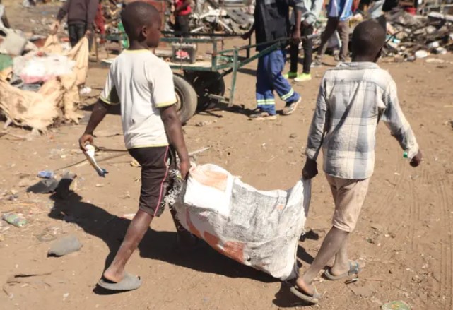 Các bé trai phải vật lộn để kiếm sống bằng cách giao sắt vụn cho một bãi đất ở Hopley gần thủ đô Harare của Zimbabwe. Ảnh: Nyasha Chingono