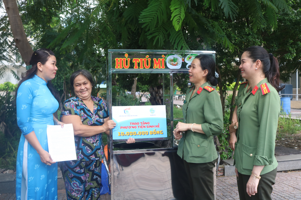 Niềm vui của chị Nguyễn Thị Ngọc Lan (thứ 2, từ trái qua) khi được hỗ trợ vốn và một xe bán hủ tíu. 