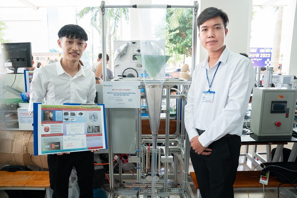 Nhóm sinh viên Huỳnh Tấn Tài (phải) với thiết kế máy định lượng và đóng gói sản phẩm hạt, bột- Ảnh: HUTECH