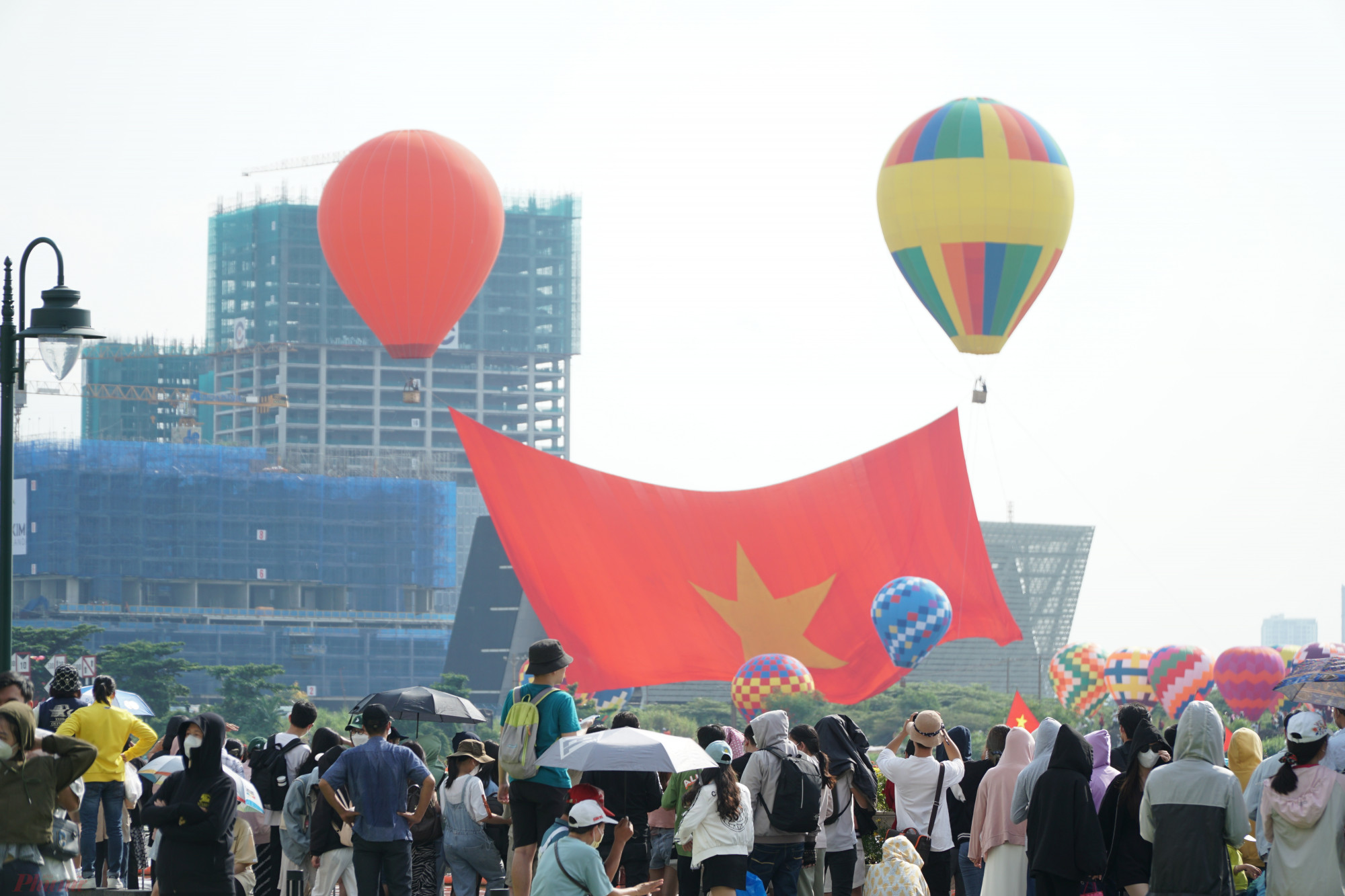 Ở phía bờ sông Sài Gòn (quận 1), hàng trăm người cũng chăm chú theo dõi quá trình đại kỳ được kéo lên cao.