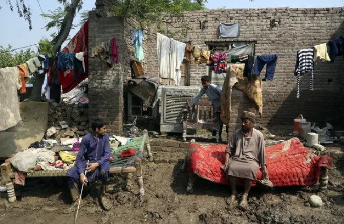 Một gia đình nghỉ ngơi sau khi vớt đồ đạc từ ngôi nhà bị lũ lụt của họ, ở Charsadda, Pakistan. Ảnh: Muhammad Sajjad / AP