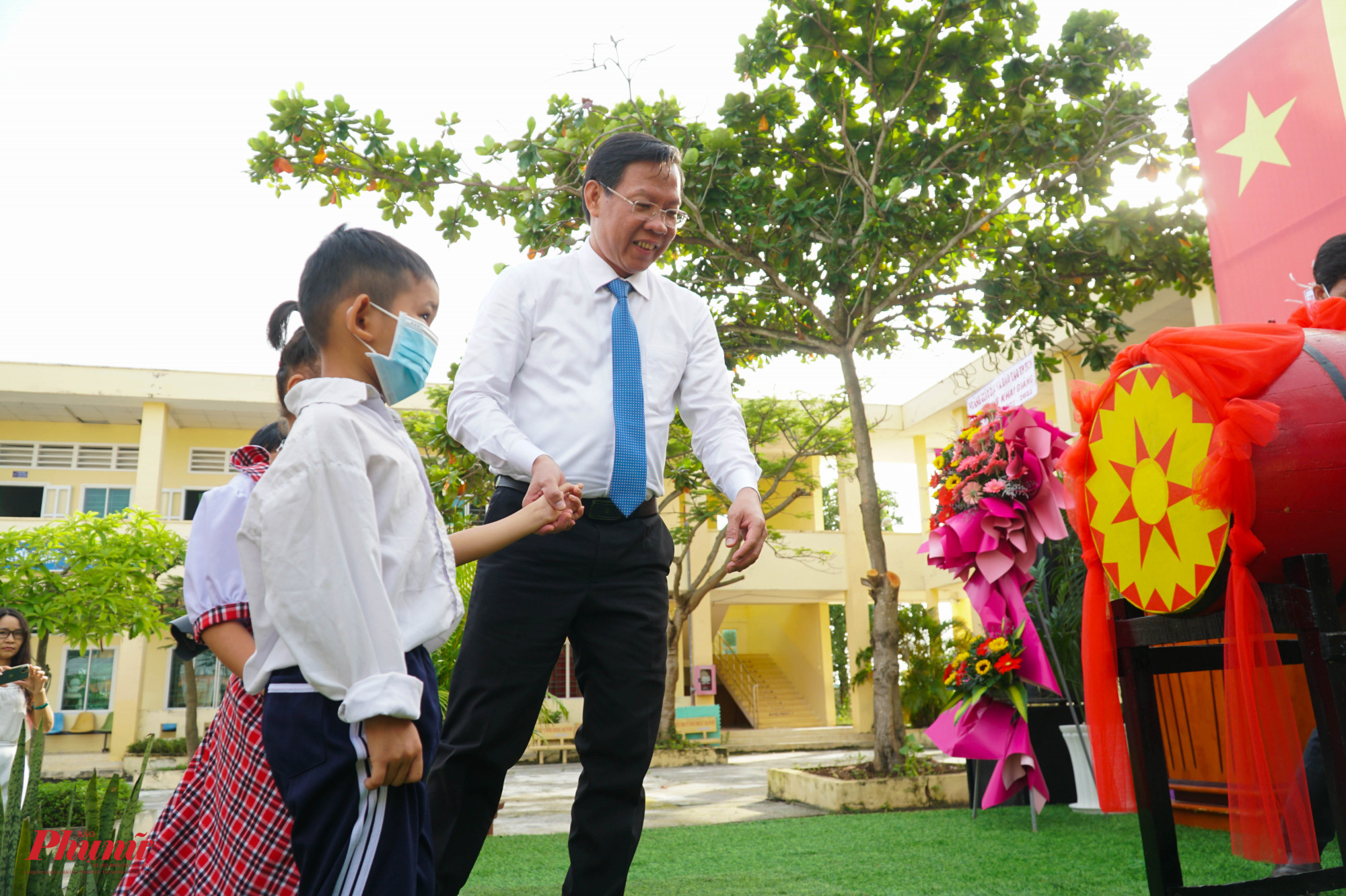 Ông Phan Văn Mãi - Chủ tịch UBND TPCHM diều các em học sinh lớp 1 lên sâu khấu để cùng đánh trống khai giảng năm học